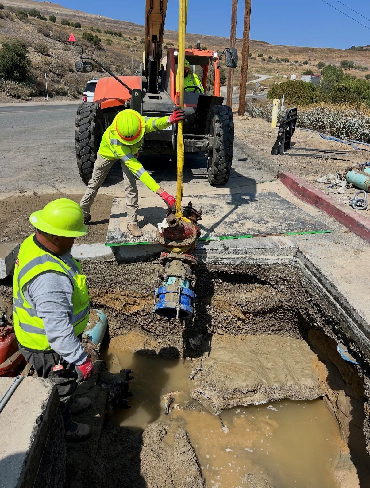 CES crew lifting a valve assembly from an excavation